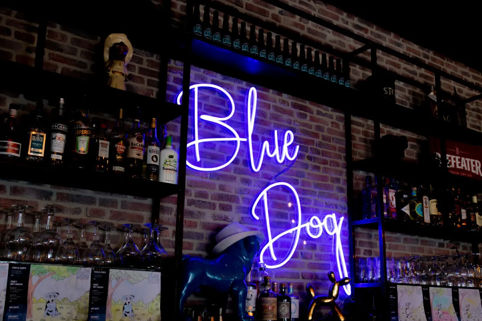 Blauer Neon-Schriftzug ‚Blue Dog‘ hinter einer Bar-Theke