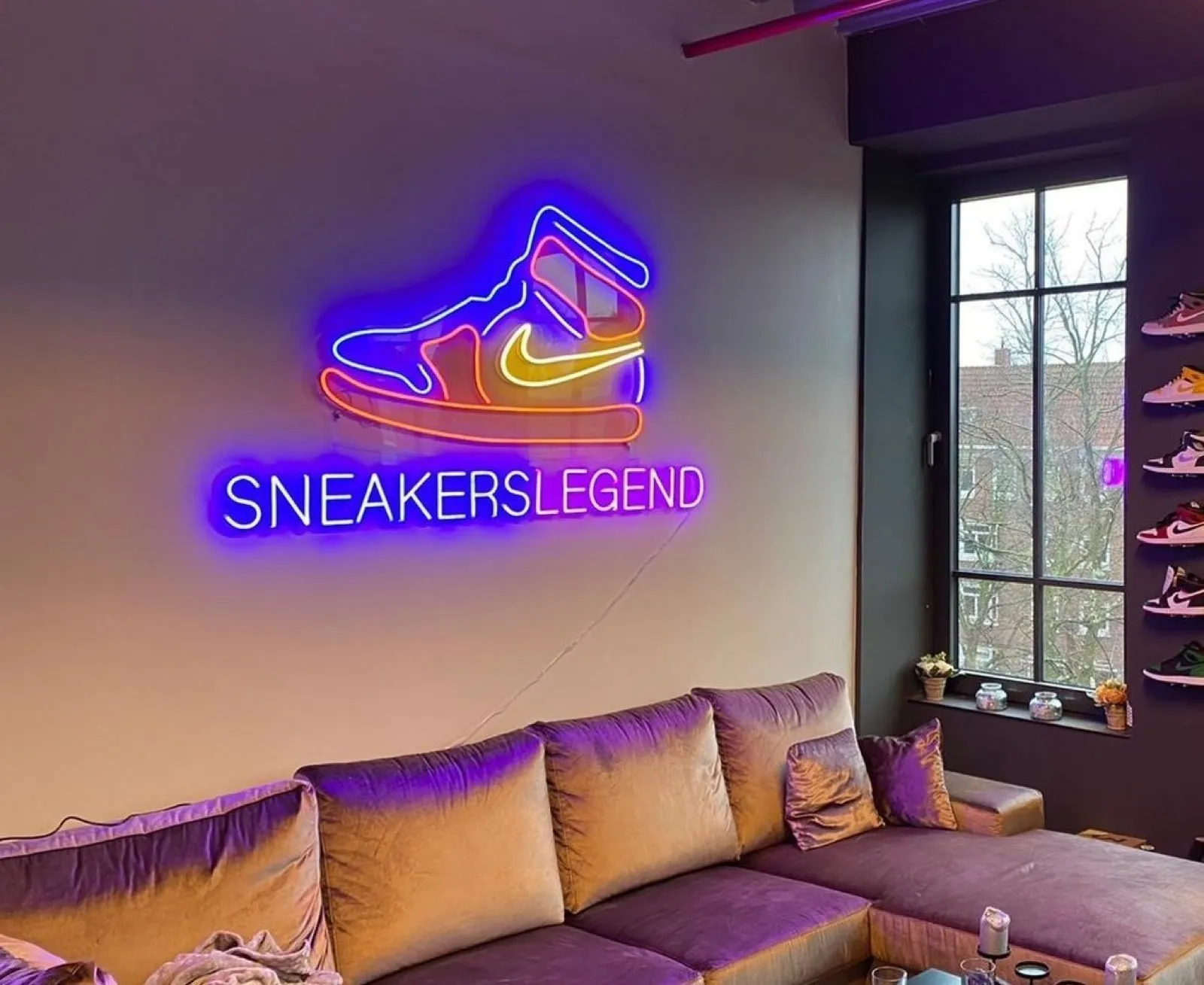 Individuelles Neon-Logo eines Sneaker-Stores über einem Sofa